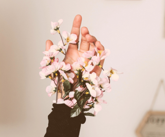 successful personal brand hand with pink cherry blossoms coming out of black sleeve
